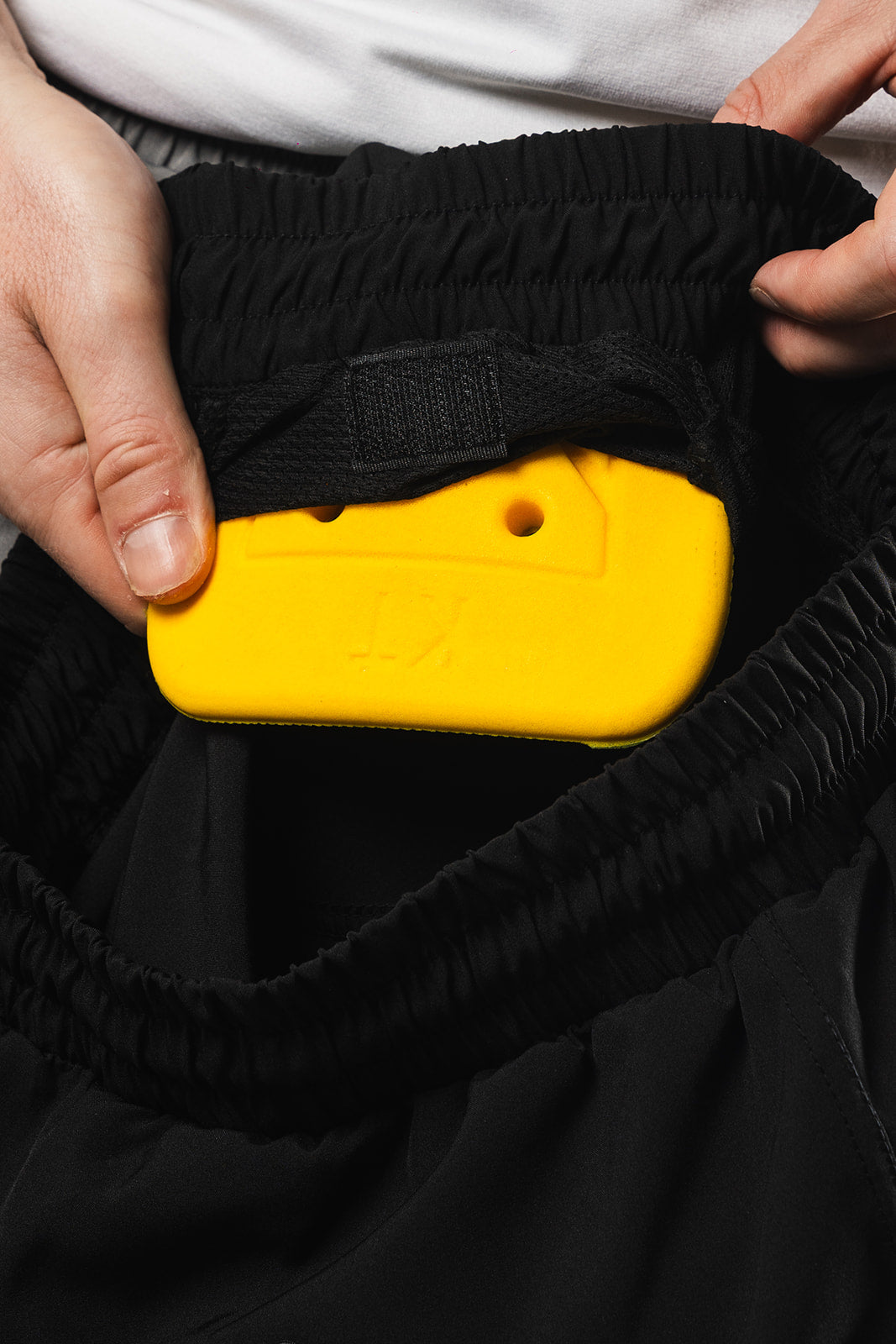 Yellow Pad being shown in Pad going into Black Padded Men's Fishing Shorts